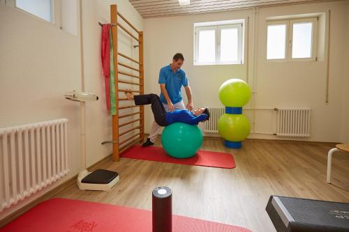 a man sitting on a ball in a room at Ferien Residenz Bergfried in Hinterzarten