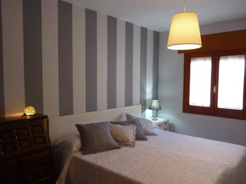 um quarto com uma cama e uma parede listrada em LA MORERIA, alojamiento turístico em Cuéllar