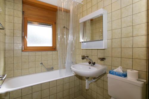 a bathroom with a sink and a bath tub at Haus Rothorn, Swiss Alps in Leukerbad