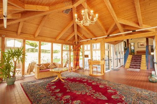a living room with a chandelier and a large rug at Ferien Residenz Bergfried in Hinterzarten