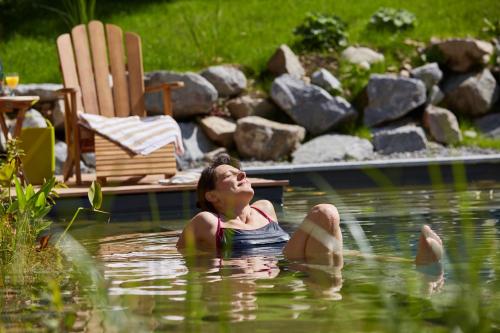 a woman floating in a pool of water at Ferien Residenz Bergfried in Hinterzarten