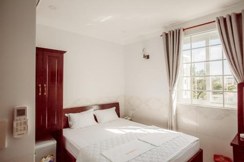a bedroom with a white bed and a window at Phu Hong Hotel in Phu Quoc