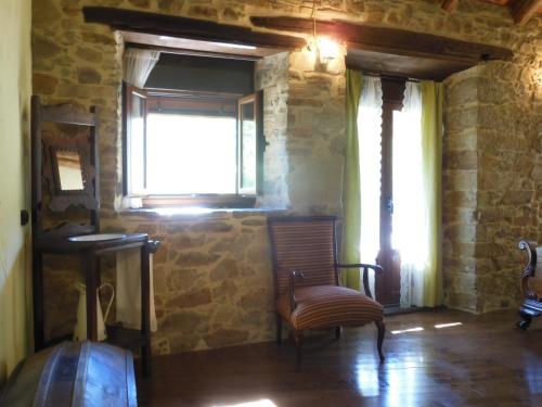 a living room with a chair and a window at Neverending Bierzo in Pobladura de las Regueras