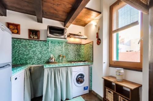 a kitchen with a washer and a washing machine at Emerald apartment in Alghero Historic Center in Alghero