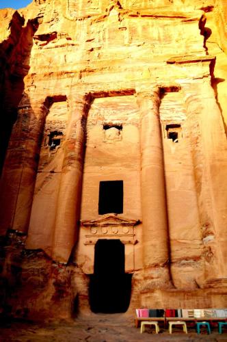 a large stone building with some chairs in front of it at Happy Bedouin House Petra in Al Ḩayy
