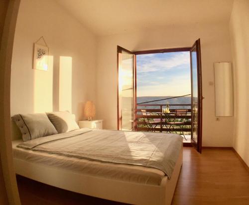 a bedroom with a large bed and a large window at Sea View Apartments Nini in Vlašići