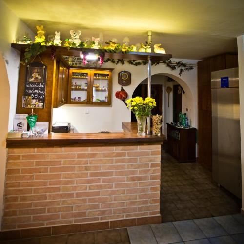 a bar with flowers on top of a brick wall at Penzion U Králíků in Kurdějov
