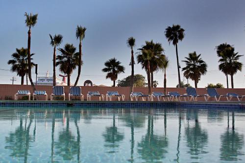 un grupo de sillas sentadas junto a una piscina en Hotel Villa Marina, en Ensenada