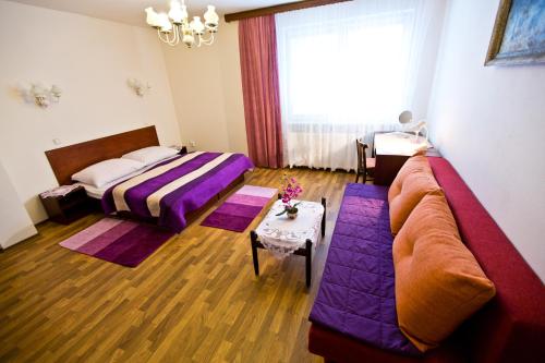 a living room with a couch and a bed at Penzion U Králíků in Kurdějov