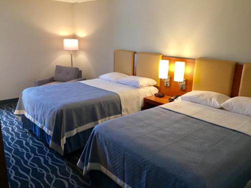 A bed or beds in a room at Days Inn & Suites by Wyndham Cincinnati North