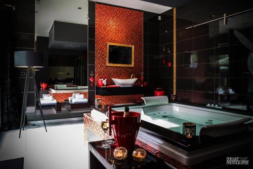 ein Badezimmer mit einer Badewanne und einer roten Wand in der Unterkunft Le Gate One in Herbesthal