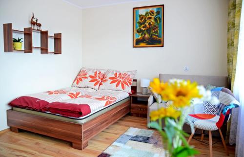 Apartament KARINA في تيلسز: غرفة نوم بسرير و إناء من الزهور