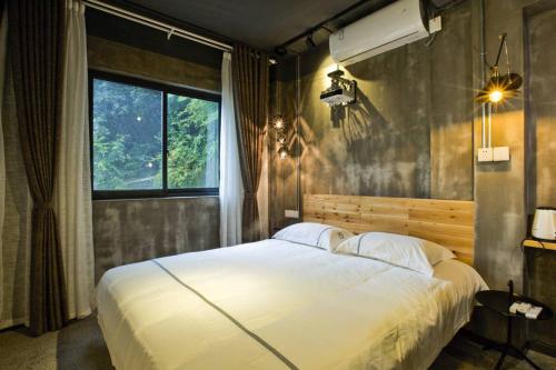 a bedroom with a large white bed and a window at 0517 Boutique Hotel in Huangshan Scenic Area