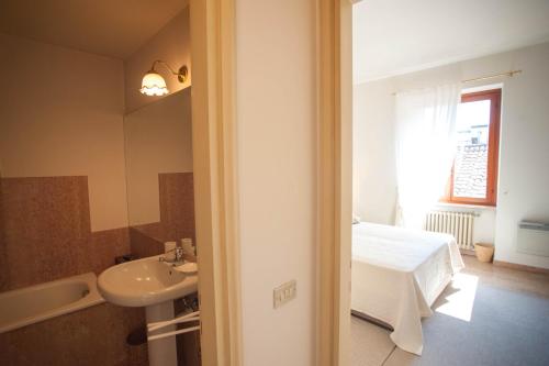 a bathroom with a sink and a bed and a mirror at Italianflat - Palazzo Zeiner in Verona
