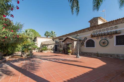 an exterior view of a house with a brick driveway at Agriturismo Papyrus in Siracusa