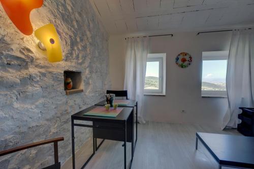 ein Wohnzimmer mit einem Tisch und einer Steinmauer in der Unterkunft THE VIEW a Pop Style Apartment in Maremma, Cana in Cana