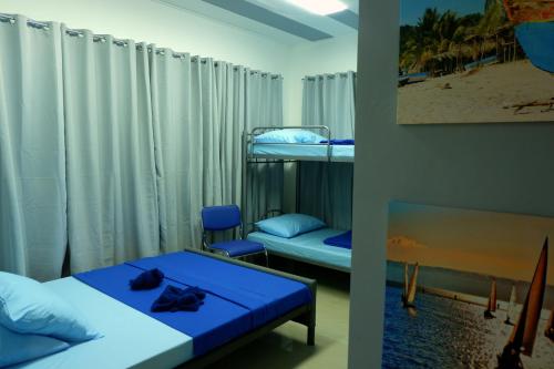 Zimmer mit 2 Etagenbetten und einem blauen Tisch in der Unterkunft Mactan-Cebu Airport Budget Hotel in Mactan