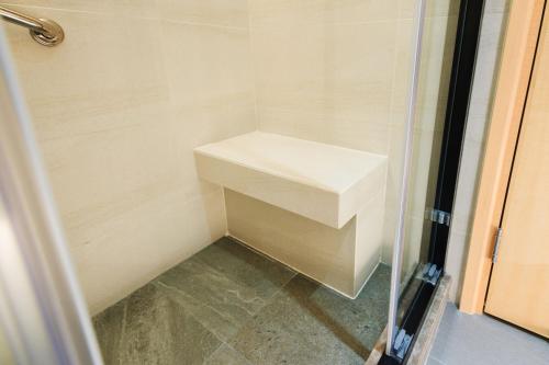 a small shower with a white sink in a bathroom at Metropark Hotel Mongkok in Hong Kong