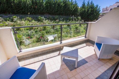 a balcony with a table and chairs and a view of a garden at Cefalù Sea Palace in Cefalù