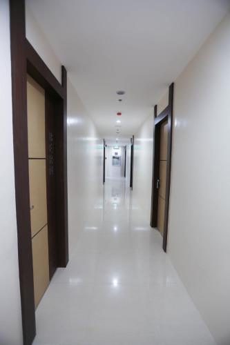 an empty hallway in a building with doors and floors at Bed and Bath Serviced Suites in Iloilo City
