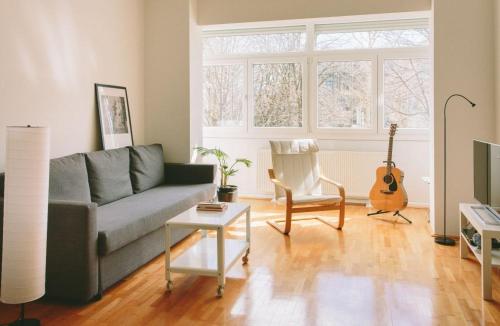 a living room with a couch and a guitar at Apartment Savska in Zagreb