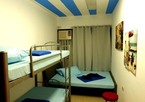 a room with two bunk beds and a blue ceiling at Transit Point Hostel Mactan Cebu in Mactan