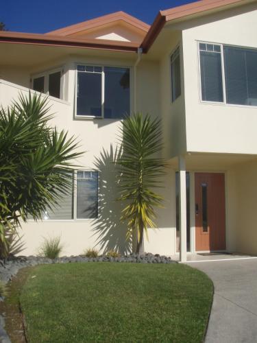 a house with a palm tree in front of it at Seascape Villa B&B in Tauranga