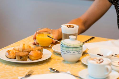 una mesa con un plato de comida y una taza de zumo de naranja en La Stua, en San Cassiano