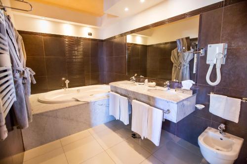 a bathroom with a sink and a tub and a toilet at Cefalù Sea Palace in Cefalù