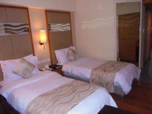 a hotel room with two beds in a room at Lords Plaza Ankleshwar in Ankleshwar