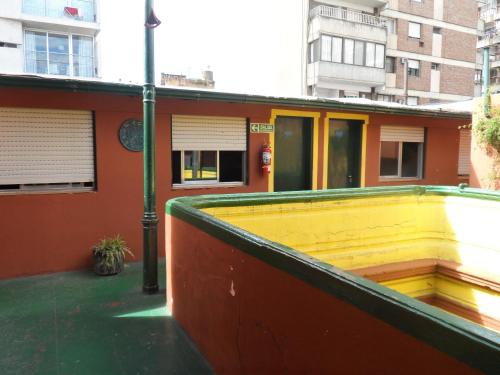 a yellow building with a yellow door and a green roof at Freedom Hostel in Rosario