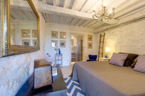 a bedroom with a bed and a mirror on the wall at THE RETREAT a romantic bedroom in Maremma in Cana