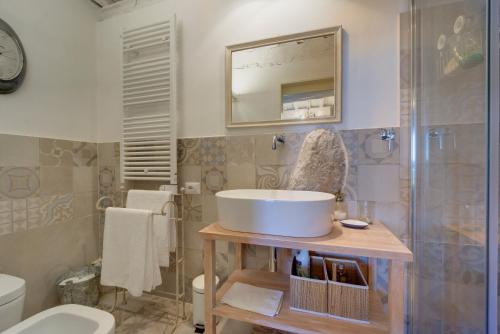 a bathroom with a sink and a toilet and a mirror at THE RETREAT a romantic bedroom in Maremma in Cana