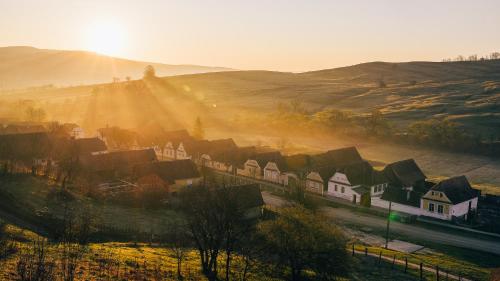 a village with houses on a hill with the sun setting at Casa Kraus in Criţ