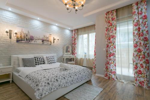 a bedroom with a white bed and a brick wall at VIP Apartamenty Stara Polana in Zakopane