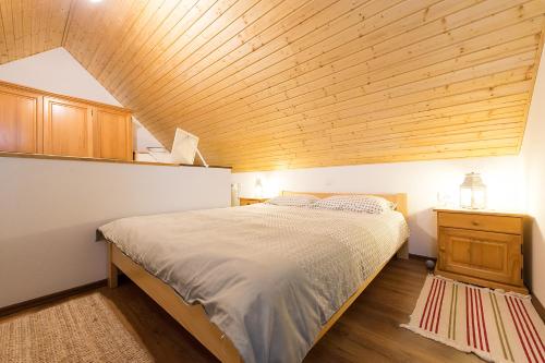 Un dormitorio con una cama y un techo de madera. en 4 Seasons House, en Roč