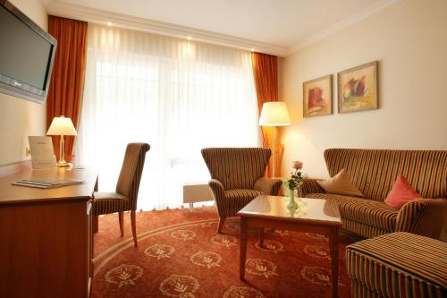 a hotel room with a couch and a tv at Hotel Ochsen in Höfen an der Enz