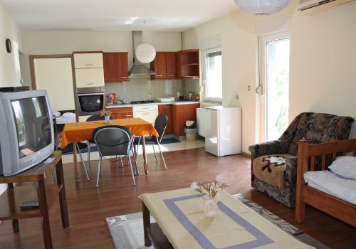 a living room with a couch and a table with a tv at Guest House Business in Valpovo