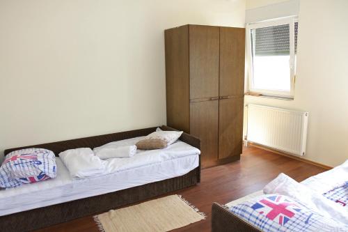 a living room with two beds and a cabinet at Guest House Business in Valpovo