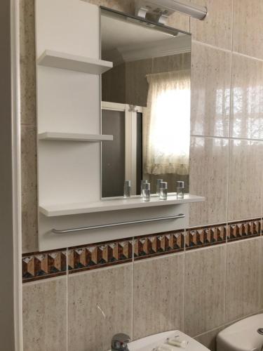 ein Badezimmer mit einem Spiegel und einem Waschbecken in der Unterkunft Apartamento Avenida in Puerto de Santiago