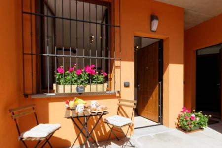 a balcony with a table and chairs and a window with flowers at B&B London 2010 in Vizzola Ticino