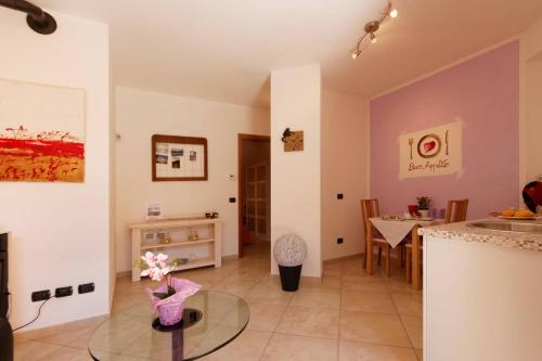 a living room with a glass table and a kitchen at B&B London 2010 in Vizzola Ticino