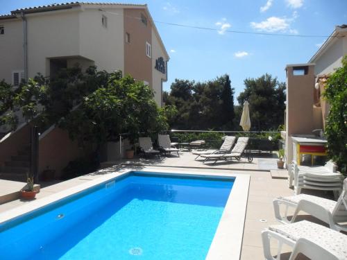 a swimming pool in front of a house at Apartments Villa Natali - Heating Pool in Trogir