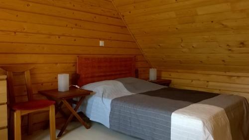 a bedroom in a log cabin with a bed and a chair at Entre Paimpol et Bréhat ! in Ploubazlanec