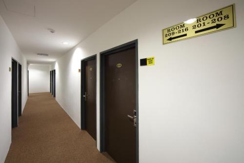 a hallway with doors and a sign on the wall at Grand Inn Hotel - Macalister Road in George Town