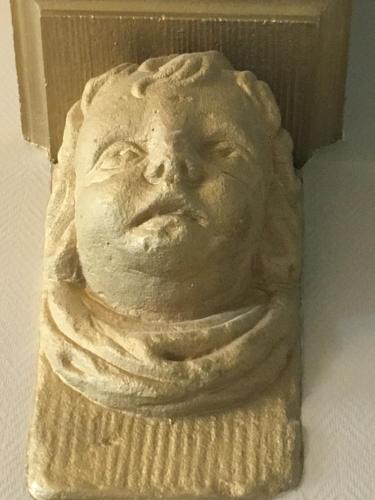 a statue of a face on a wall at ExLibris Boutique Hotel in Leiden