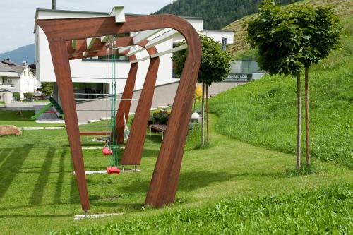a wooden arch in the grass in a yard at Ferienwohnung Robi in Fulpmes