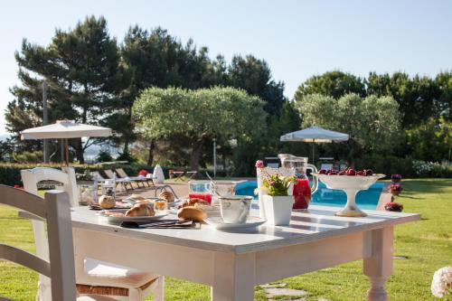 una mesa blanca con comida en un patio en Casa Tentoni - Guest House, en Misano Adriatico