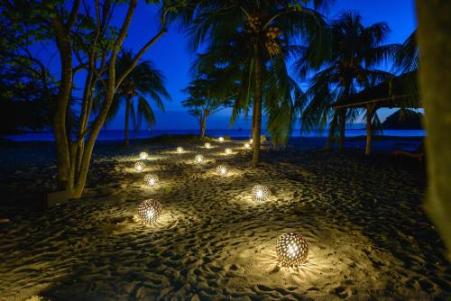 a group of lights on the beach at night at Morgan's Rock in San Juan del Sur