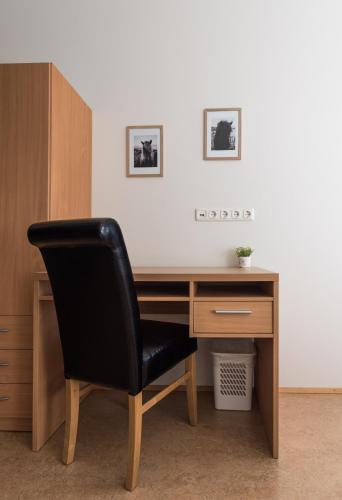 a black chair sitting in front of a wooden desk at Guesthouse Brekka in Brekka